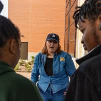 Student merchant talking with students during Student Small Business Market.